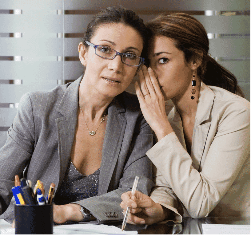 two women whispering to each other